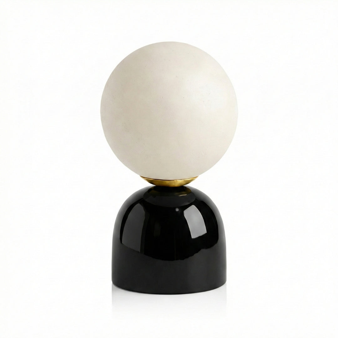 Decorative lamp with a white spherical shade and black base on a white background