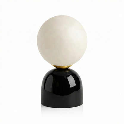 Decorative lamp with a white spherical shade and black base on a white background