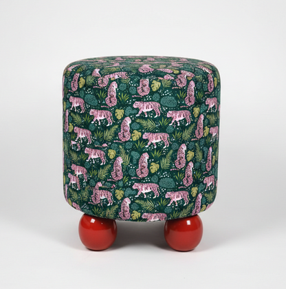 Pouf with tiger and leaf pattern on green fabric and red legs against a white background
