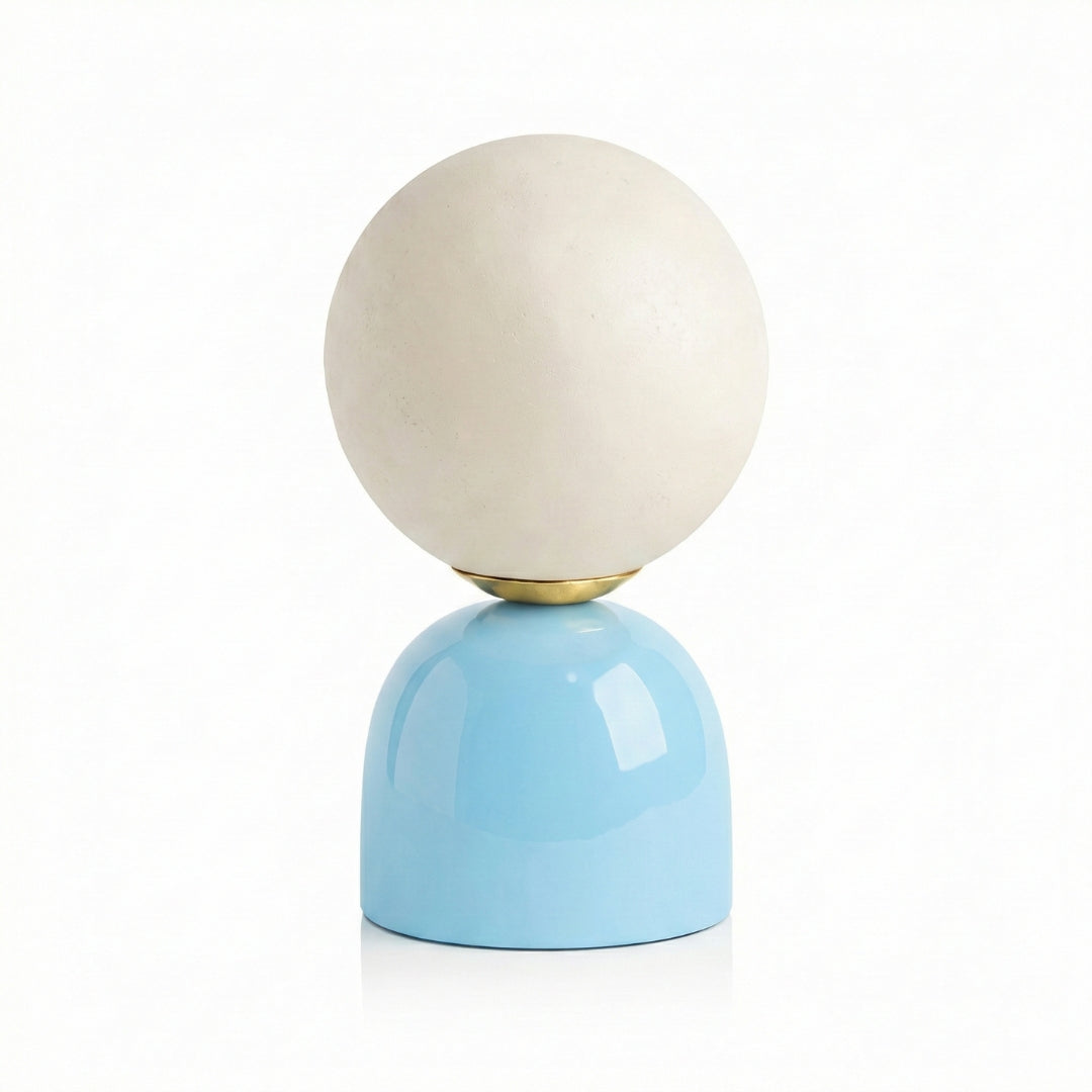 Table lamp with a white spherical shade and blue base on a white background
