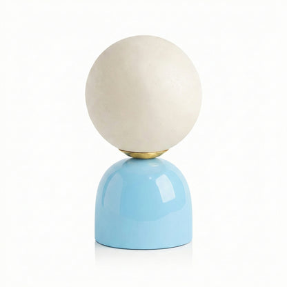 Table lamp with a white spherical shade and blue base on a white background